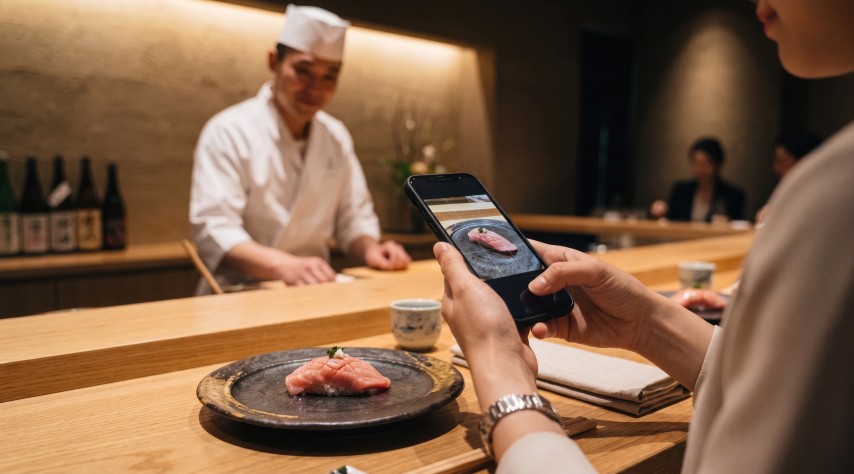 カウンターで握りをスマートフォンで撮影する手元の様子