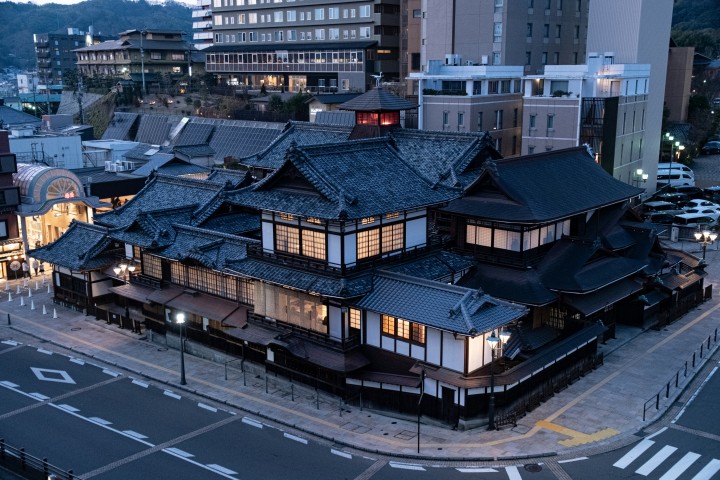 幻想的な灯りに包まれた歴史的建造物・道後温泉本館の重厚な建築美と周辺景観