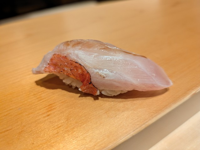 鮨はしもとの皮目が香ばしく炙られた上質な金目鯛の握り