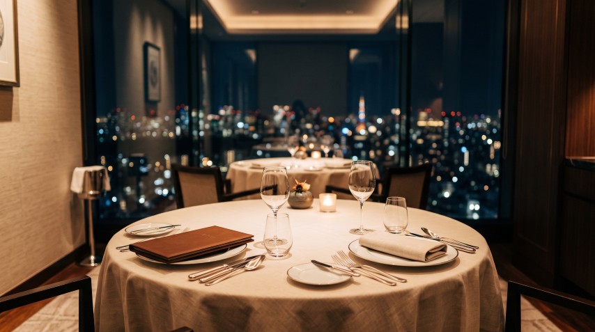 夜景を望む窓際に整えられたテーブルセッティング。高級レストランの予約席を思わせるシーン。